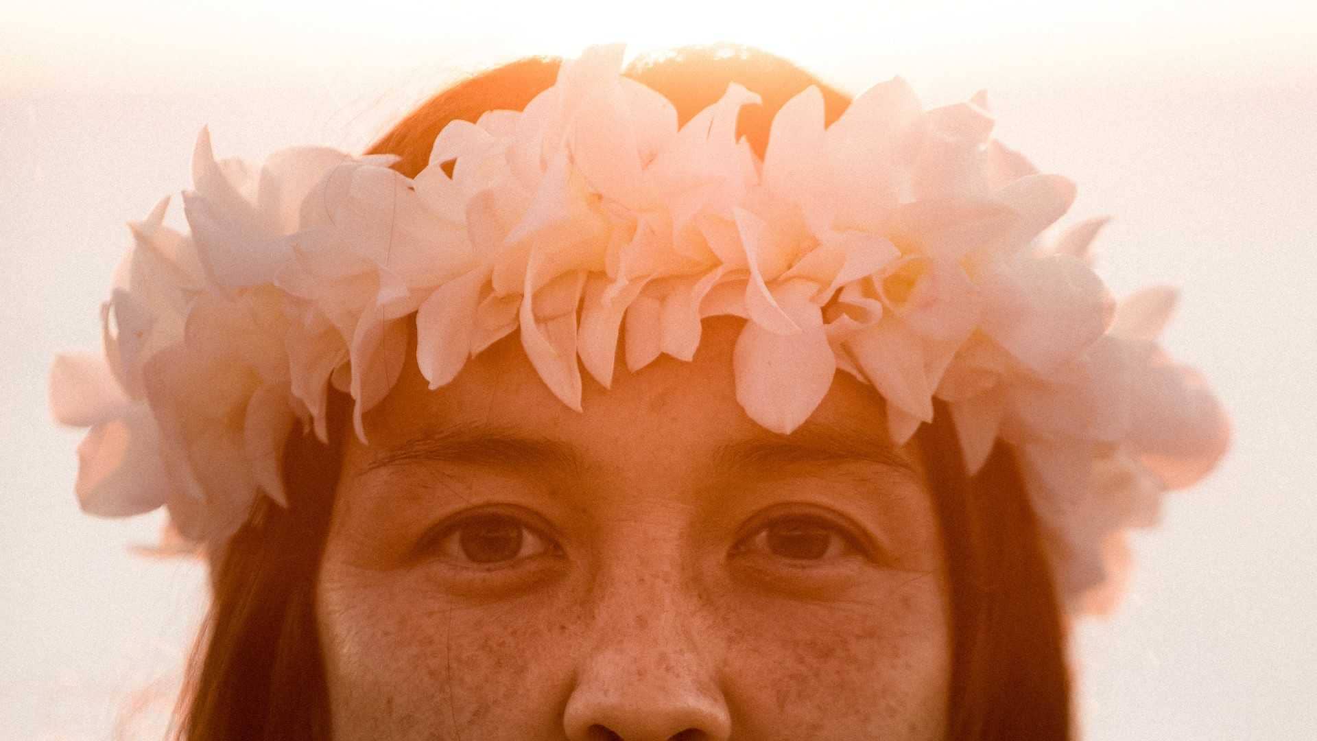 A woman wearing a Hawaiian lei on her head